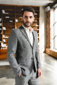 Homme en veste de laine grise mate à l'aspect flanelle, chemise blanche ouverte