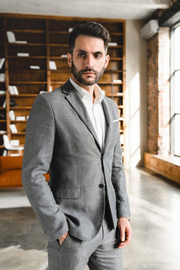 Homme en veste de laine grise mate à l'aspect flanelle, chemise blanche ouverte