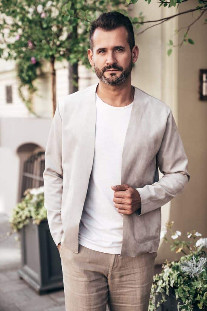 Homme en veste en lin beige non structurée, épaule souple, portée sur un tee-shirt blanc